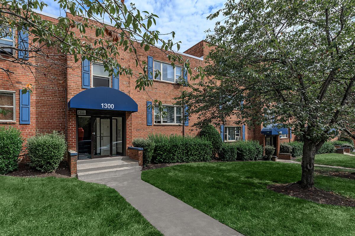 a house with a lawn in front of a brick building