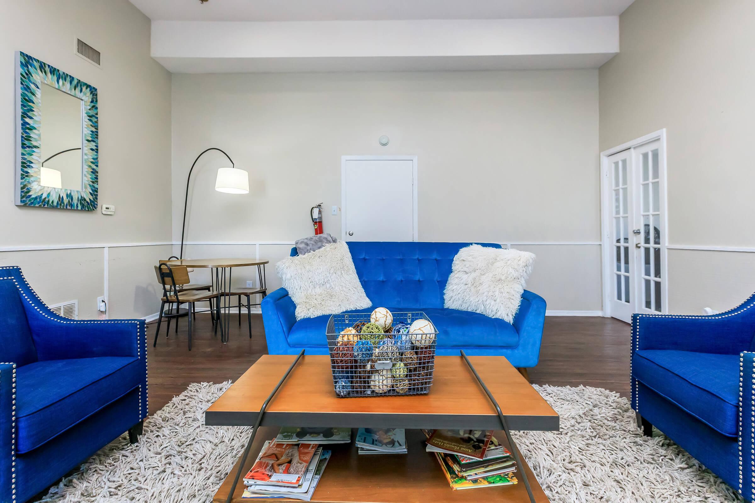 a living room with blue chairs and a table