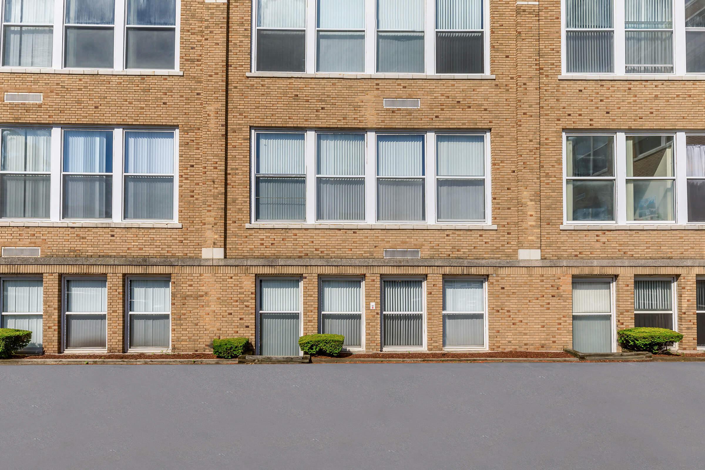 a large brown brick building next to a window