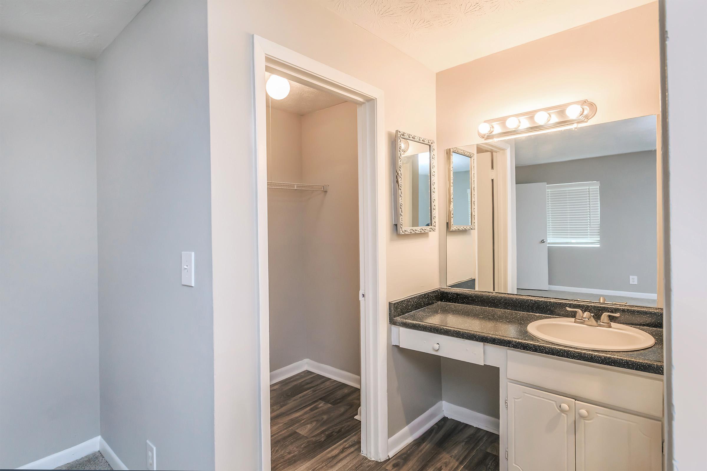 a white sink sitting under a mirror