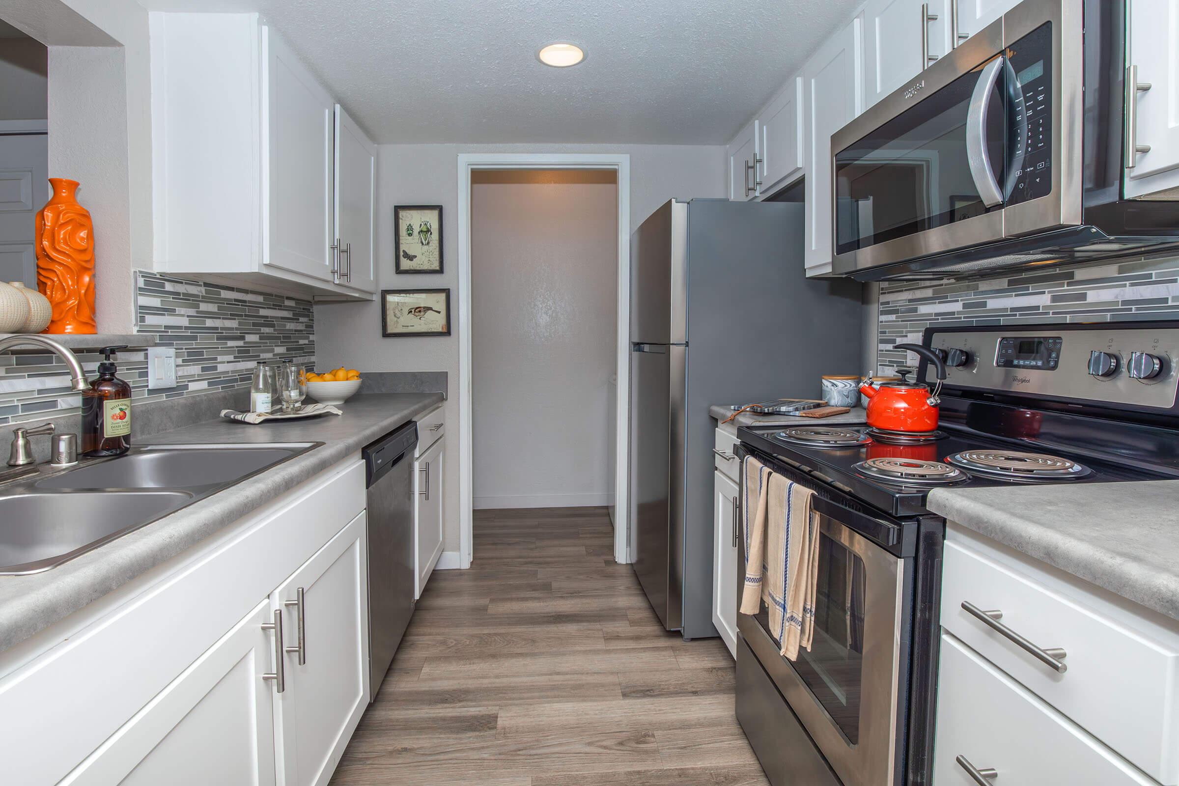 Apartments Near Vanderberg Air Force Base - Cassia - Kitchen with Stainless-Steel Appliances, Tile Backsplash, and White Modern Cabinets