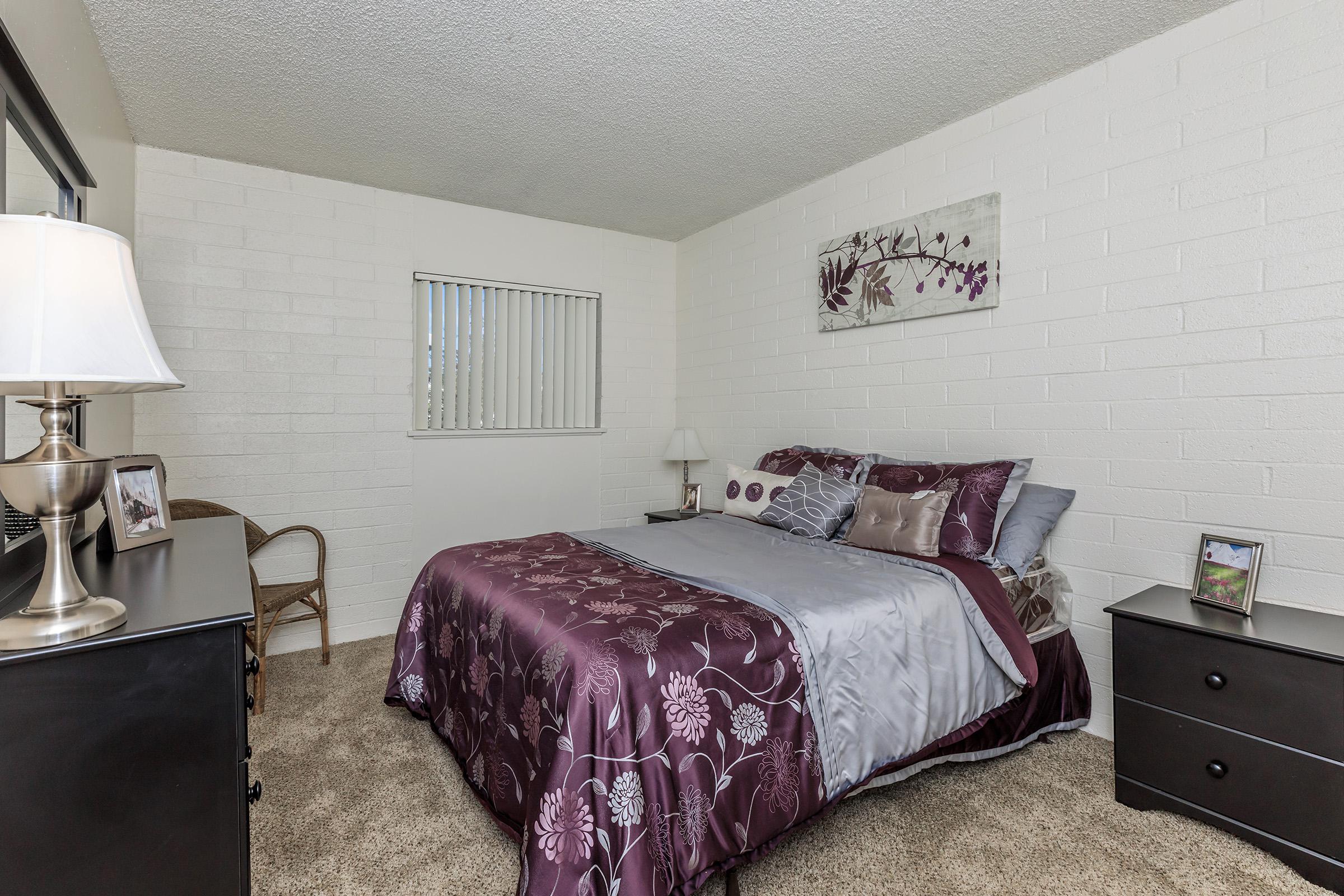 a bedroom with a bed and desk in a room