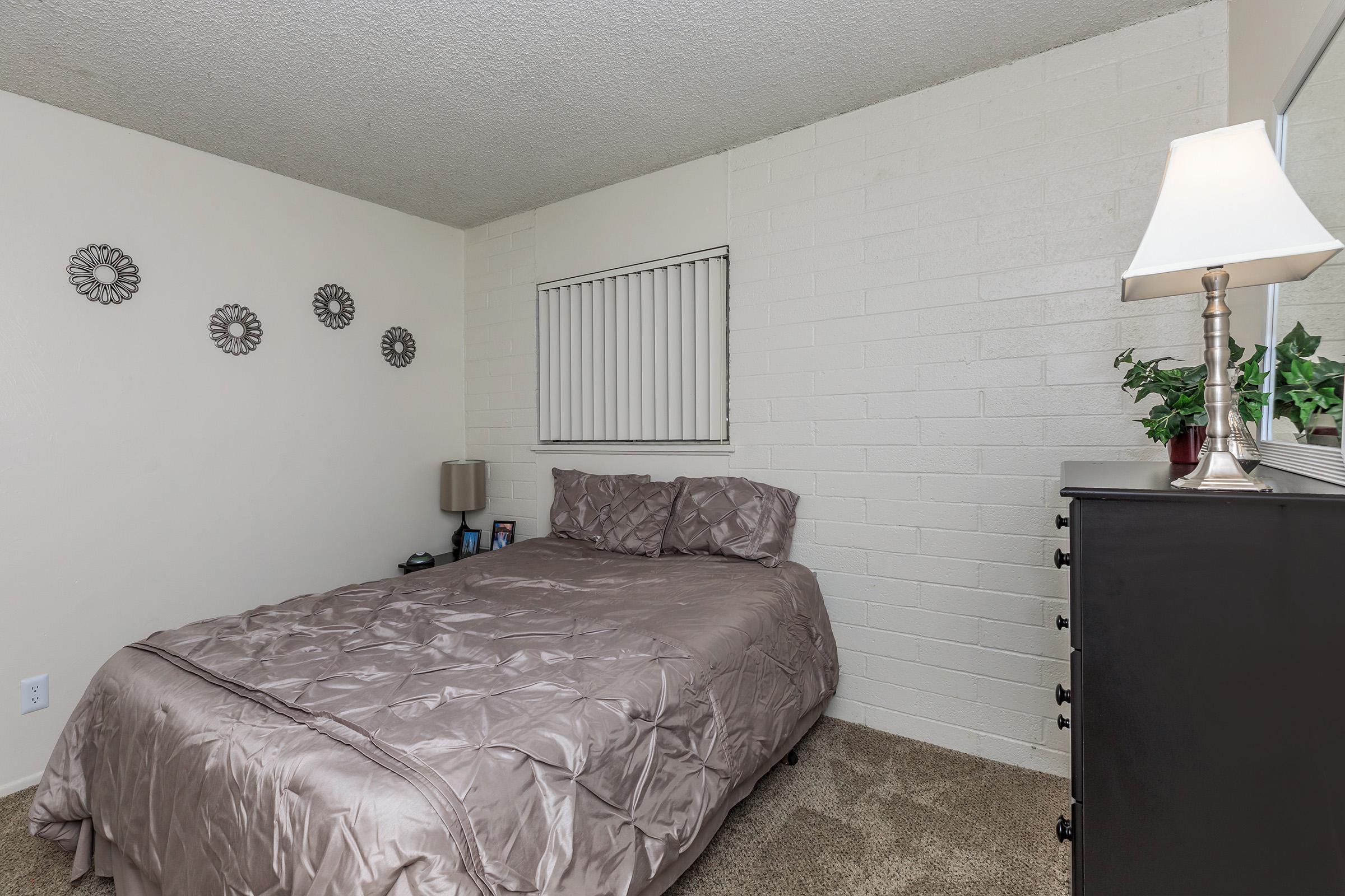 a bedroom with a bed and desk in a room