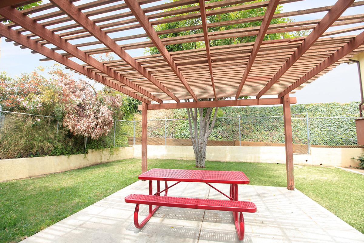 a red park bench next to a fence