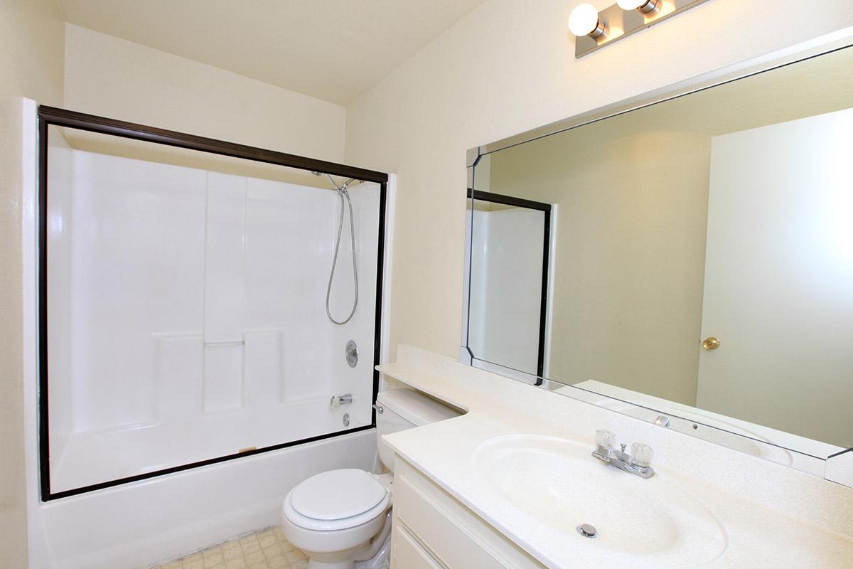 a white sink sitting next to a shower