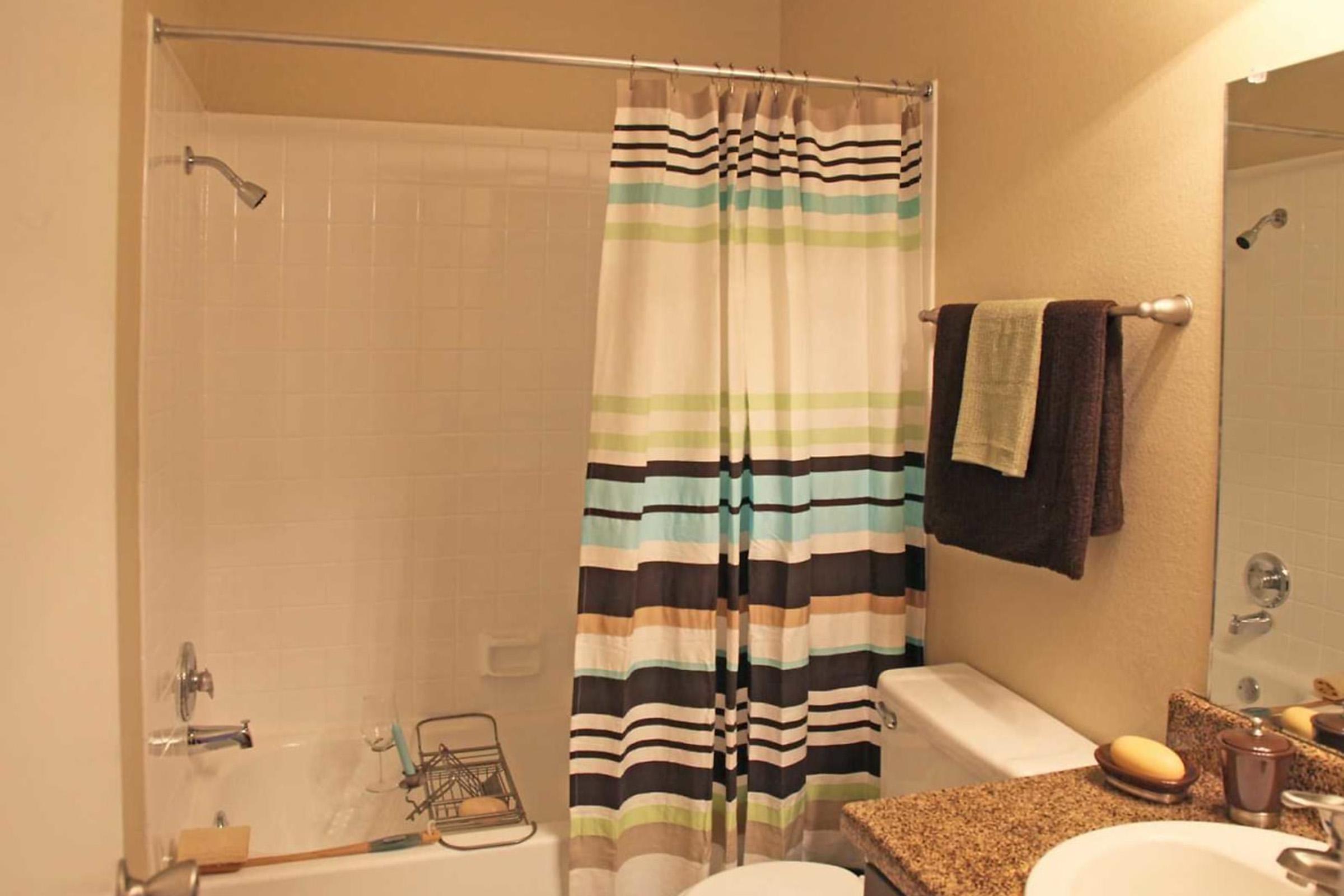 a white sink sitting next to a shower curtain