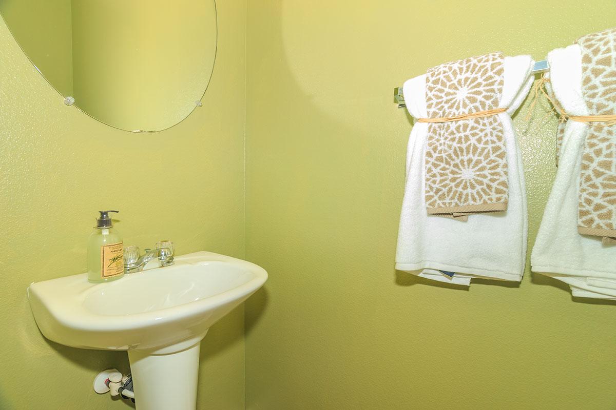 a white sink sitting under a mirror