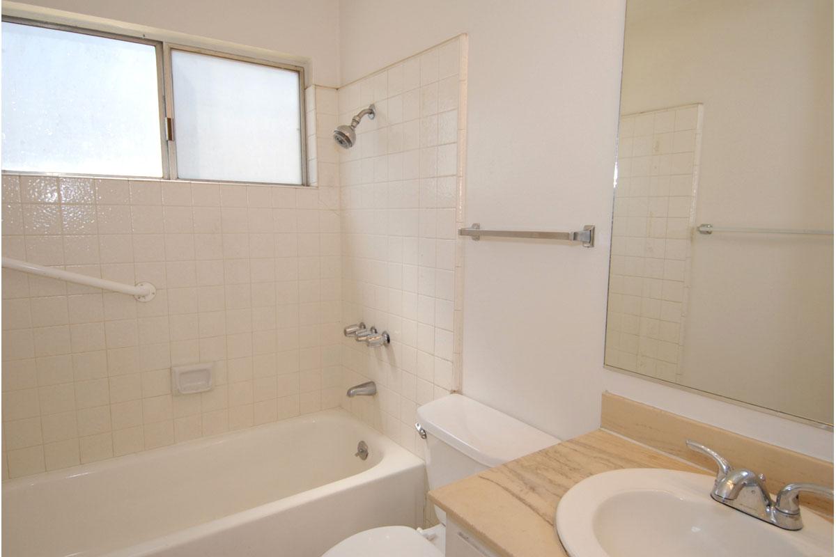 a white sink sitting under a mirror