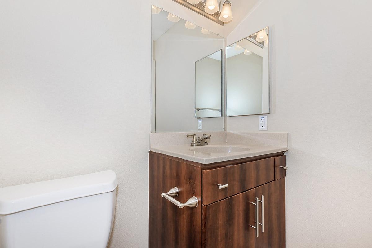 a white sink sitting under a mirror