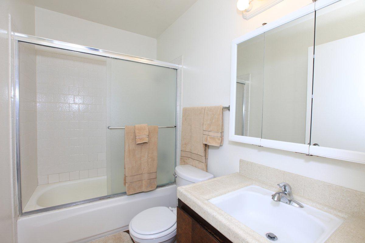 a white sink sitting under a mirror