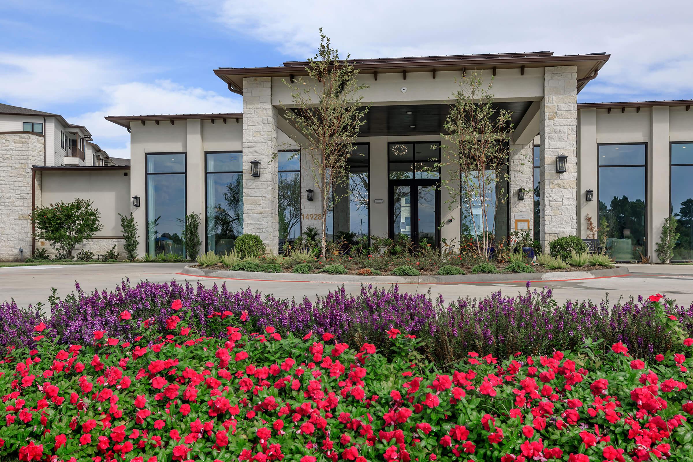 a close up of a flower garden in front of a house