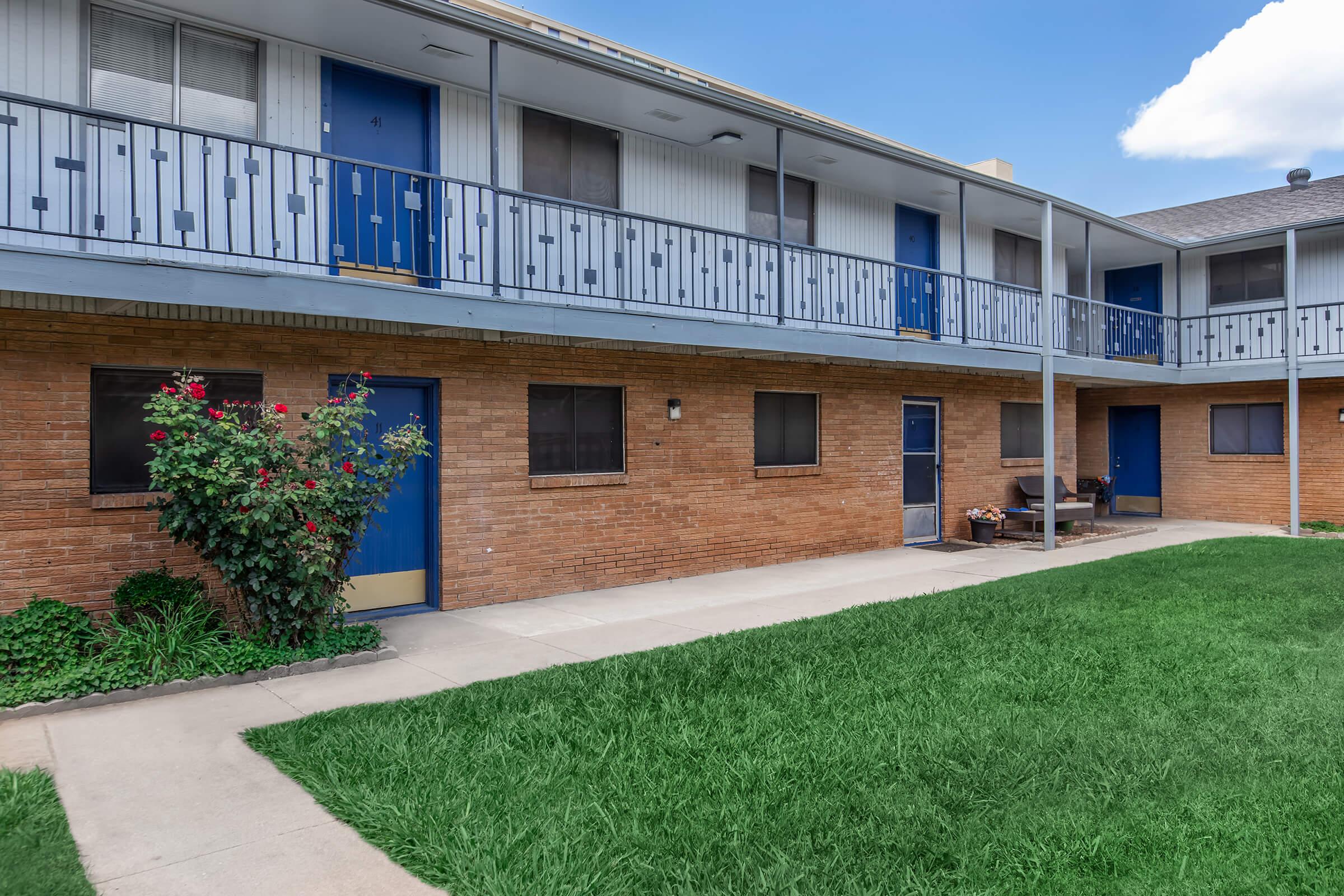 a large lawn in front of a brick building