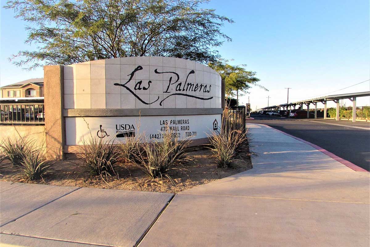 Sign for Las Palmeras, featuring the name prominently displayed in a stylish font.
