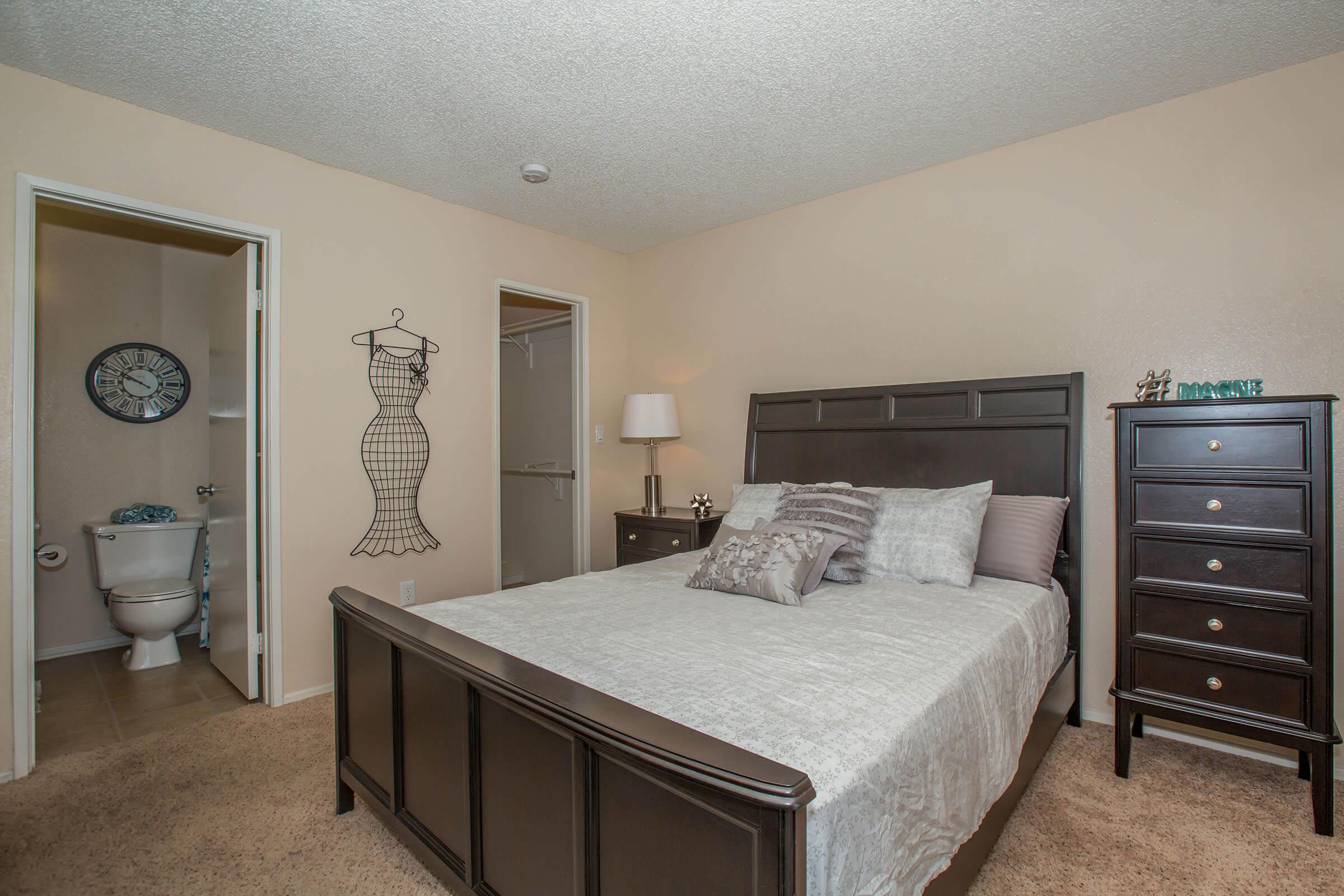 a bedroom with a bed and desk in a room