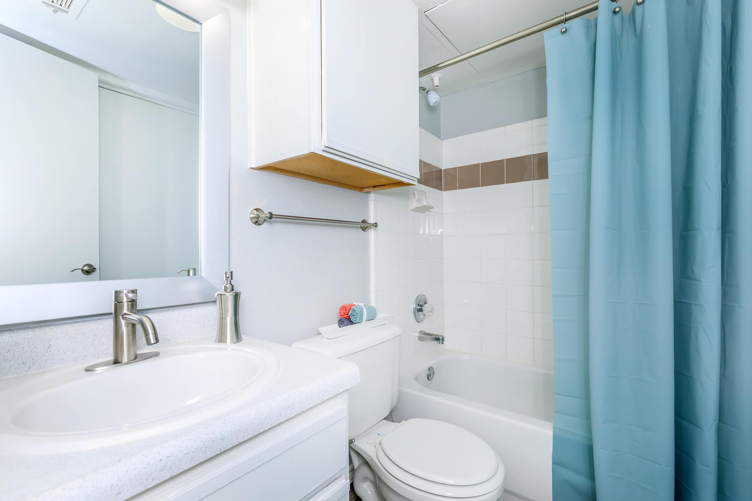 a white sink sitting next to a shower