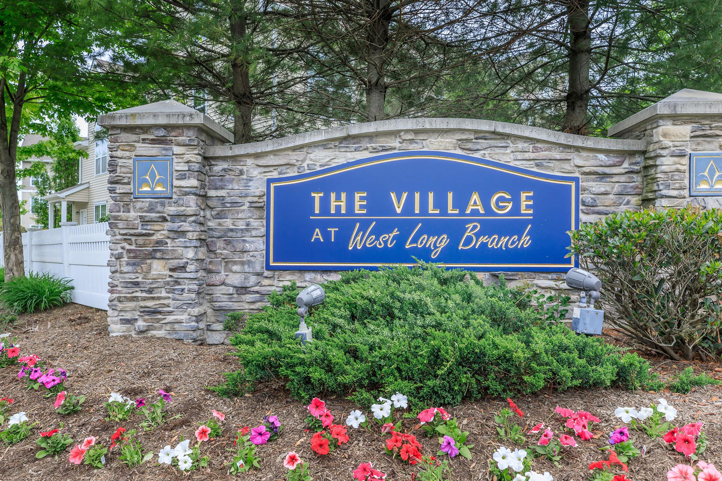 a sign in front of a flower garden