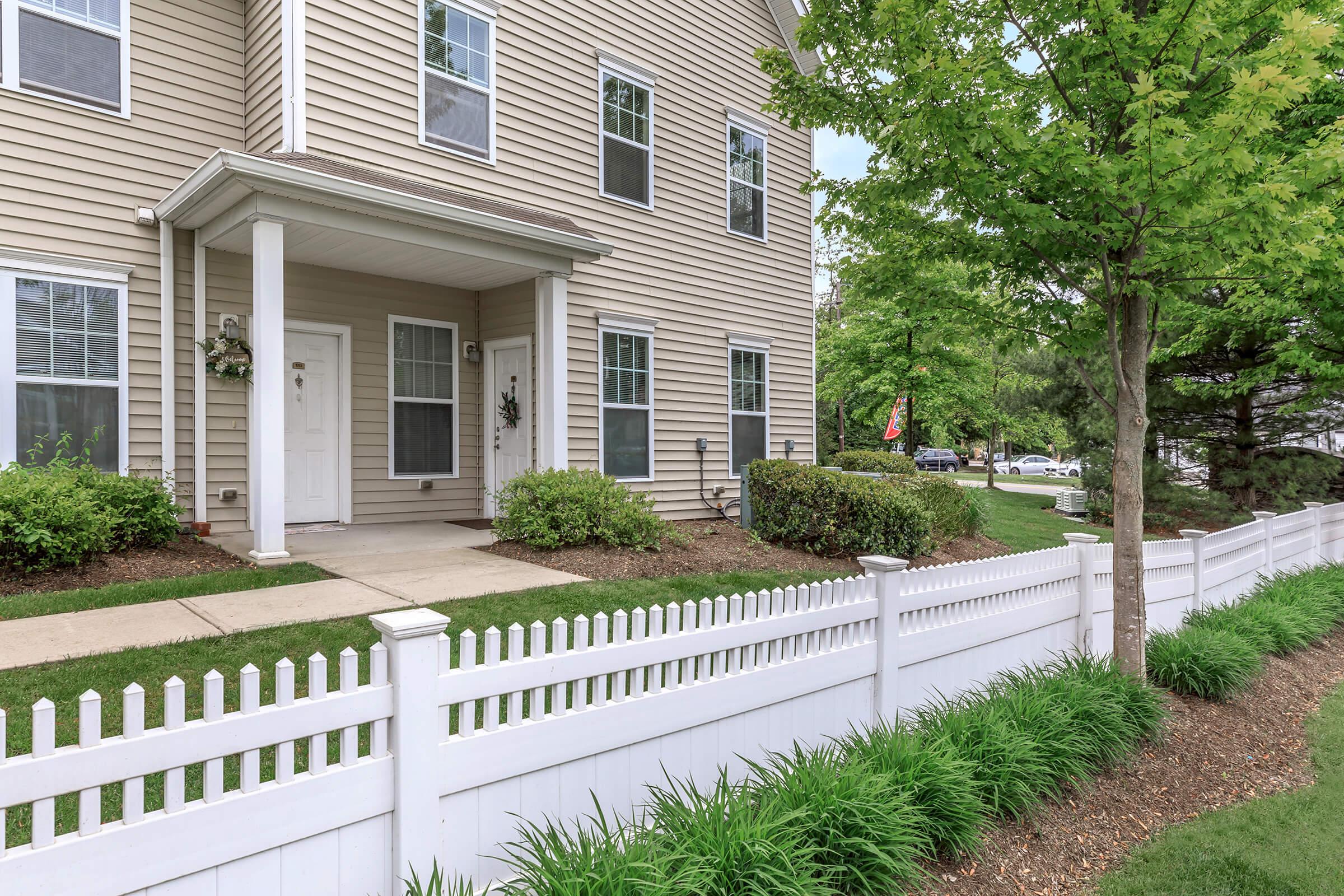 a house with a fence in front of a building