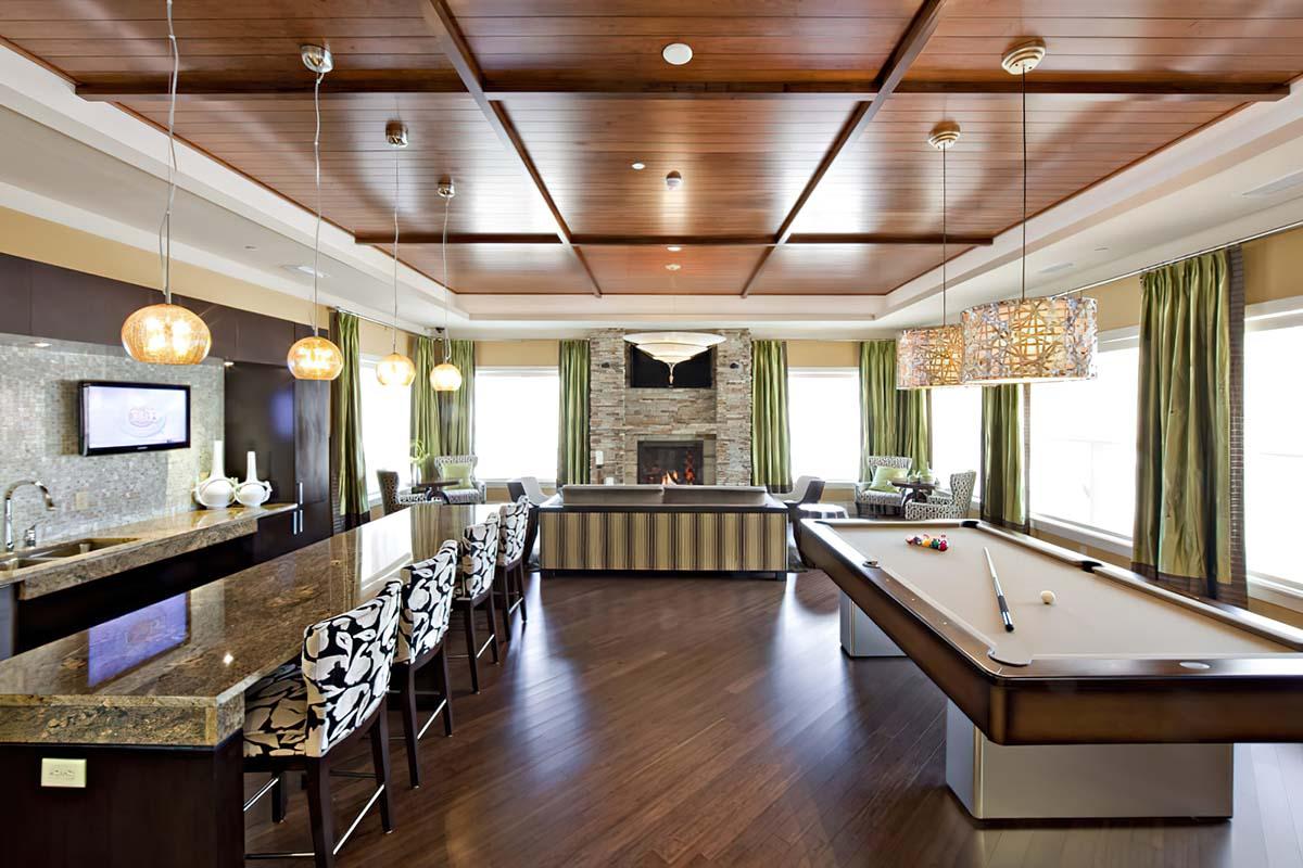 Pet-Friendly Apartments in Long Branch, NJ - The Village at West Long Branch - Clubhouse with a Billiards Table, a Kitchen Area, and a Fireplace