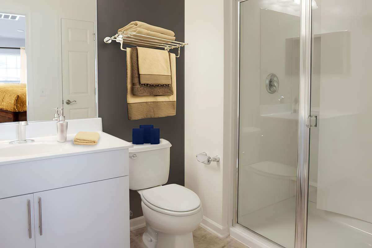 Long Branch, NJ Apartments for Rent - The Village at West Long Branch - Bathroom with a Standing Shower, a Towel Rack, and Brown Tile Flooring