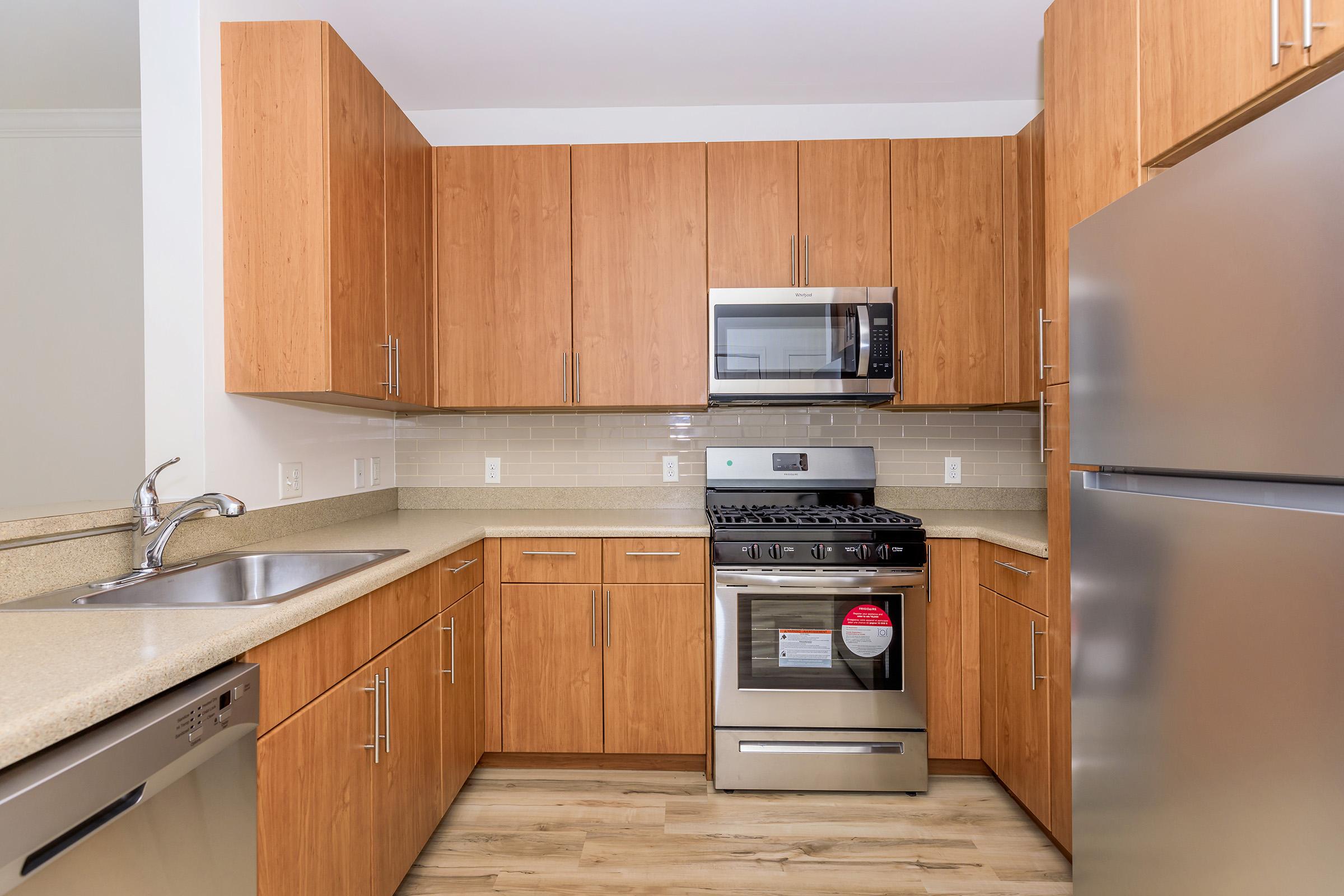 a kitchen with stainless steel appliances and wooden cabinets