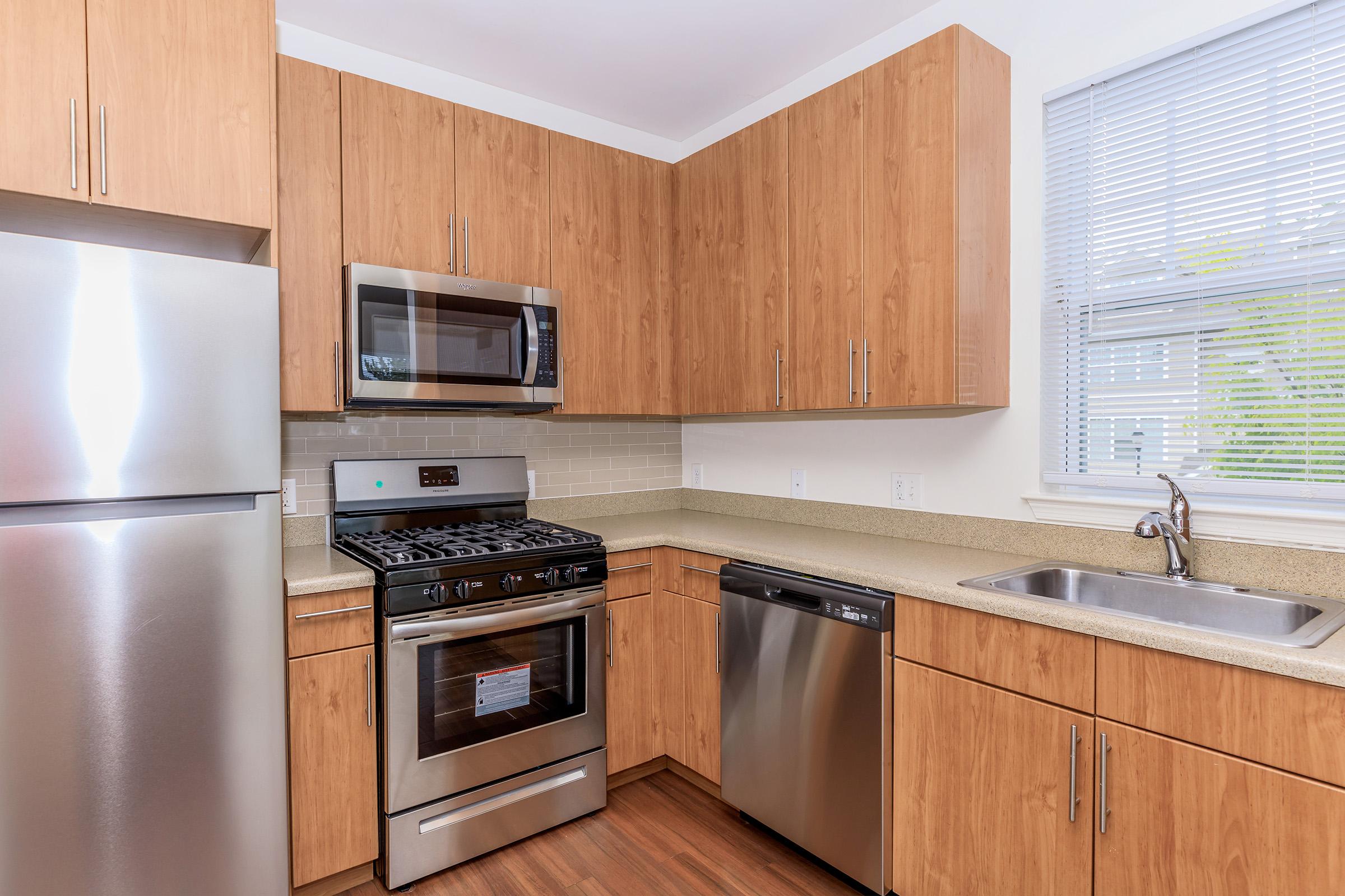 a kitchen with stainless steel appliances and wooden cabinets