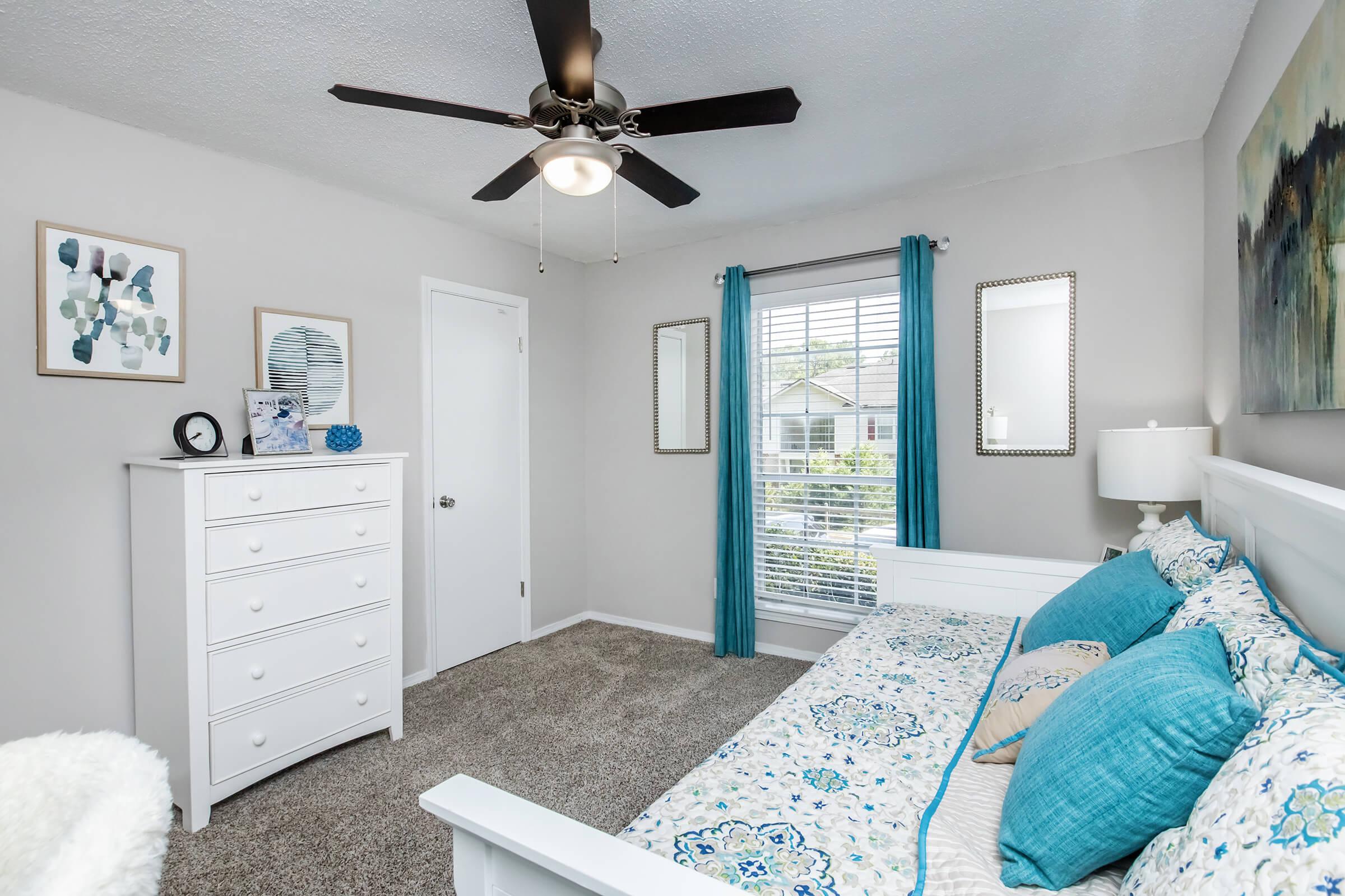 a bedroom with a bed and a mirror in a room