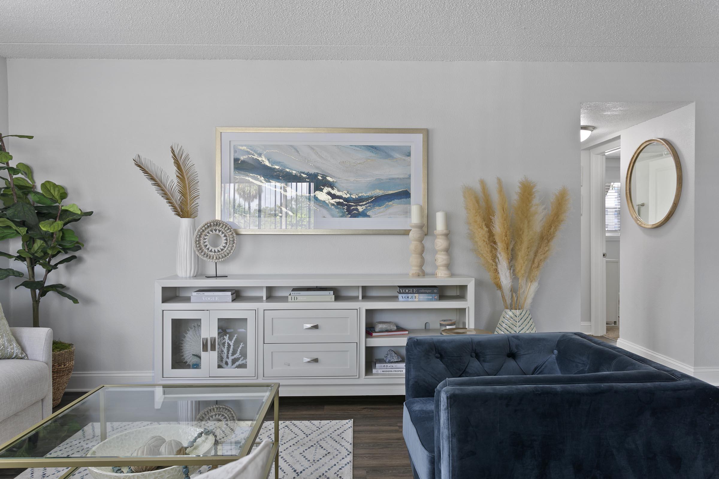 a living room filled with furniture and vase of flowers on a table