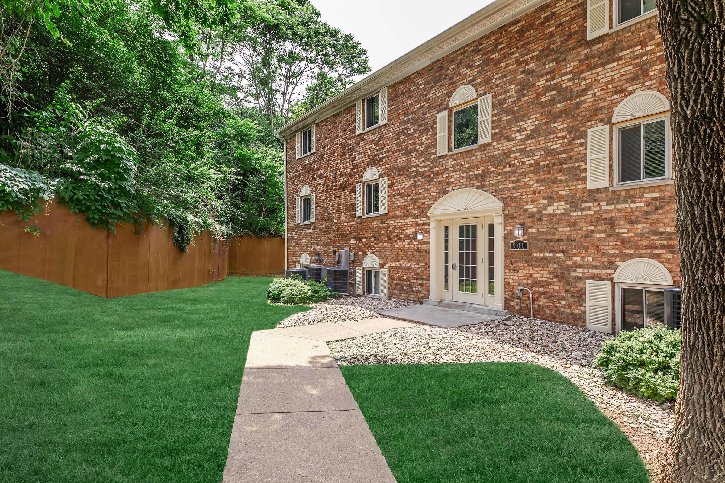 a large brick building with grass in front of a house