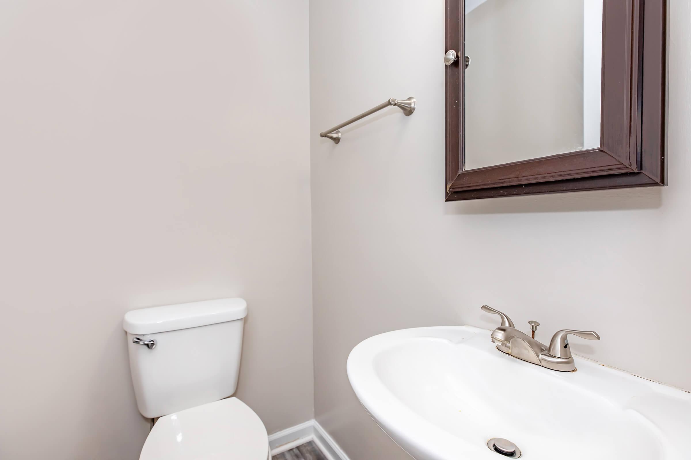 a sink sitting under a mirror