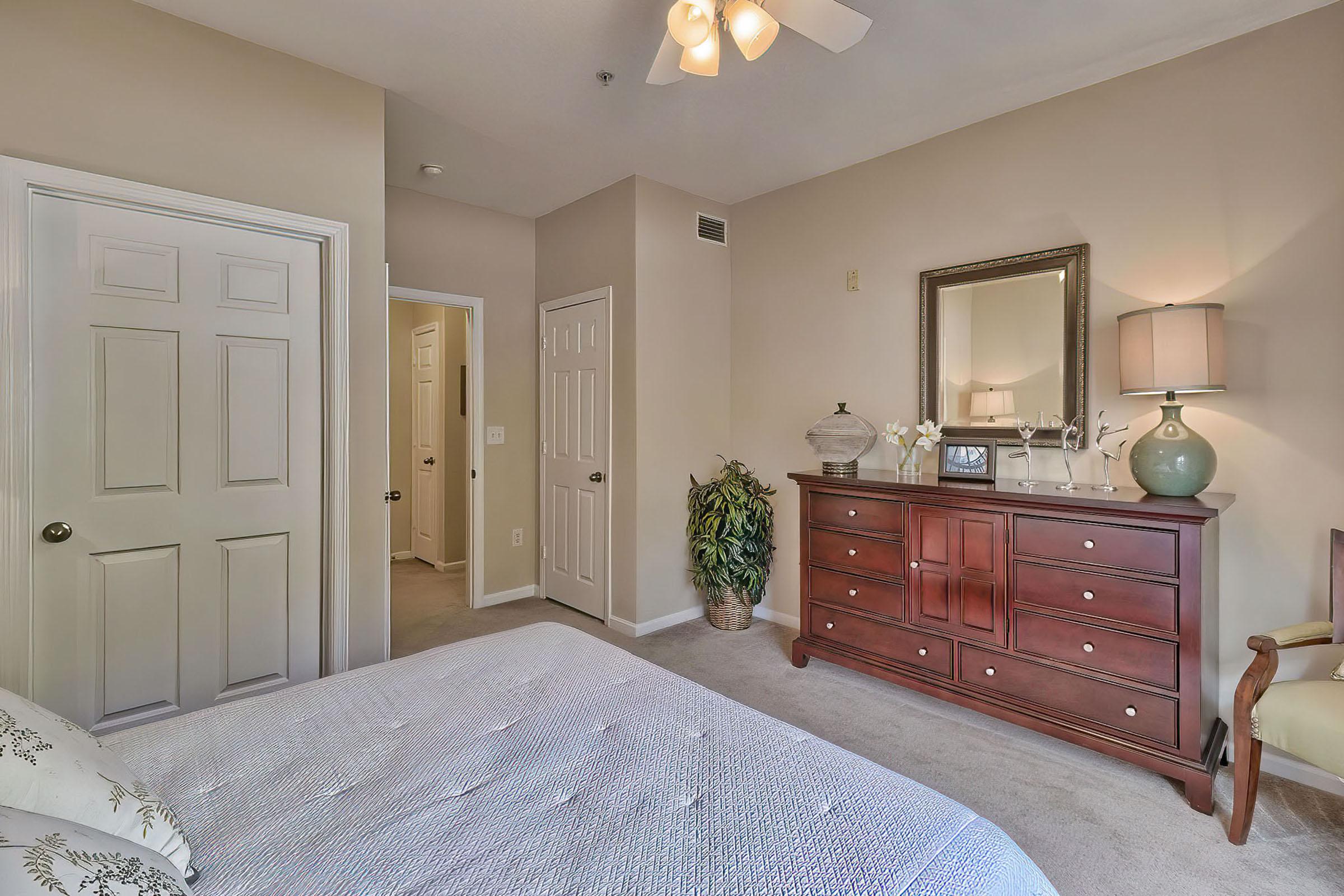 a bedroom with a bed and a mirror in a room