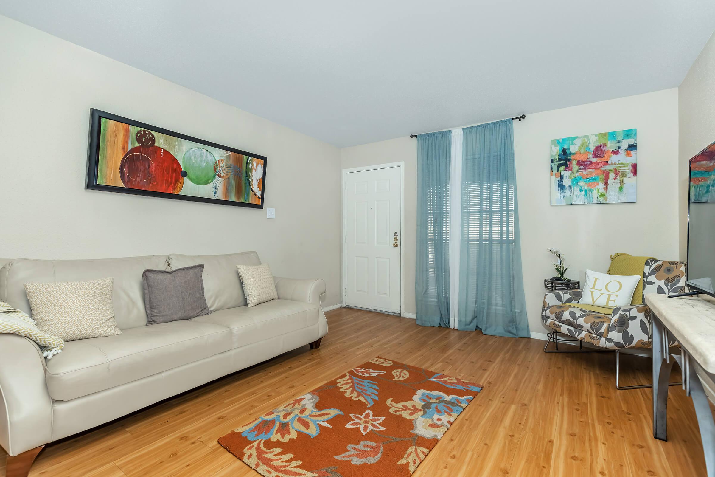 a living room filled with furniture on top of a hard wood floor