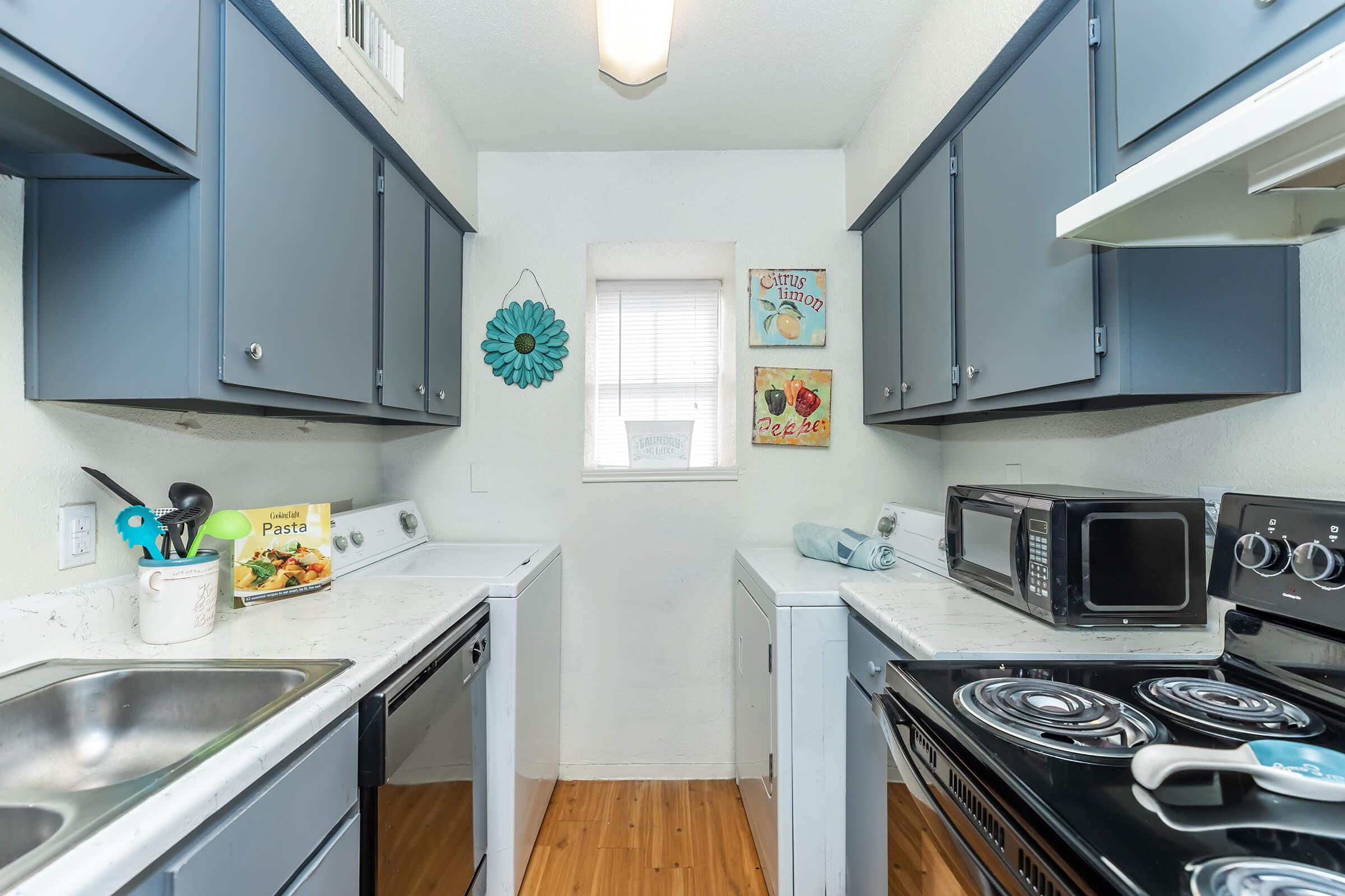 a kitchen with a stove a sink and a microwave oven on a counter