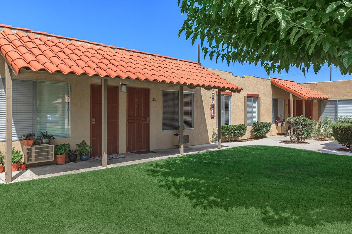 a house with a lawn in front of a brick building