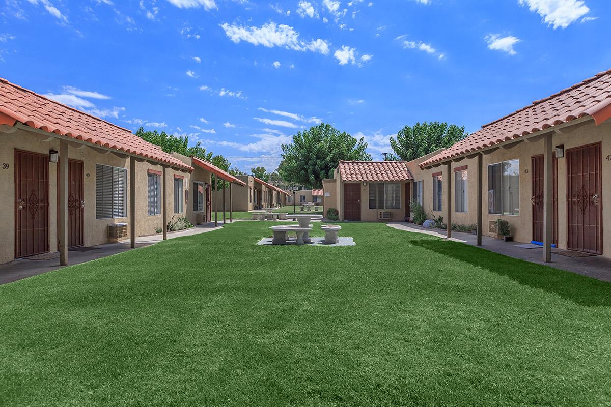 a house with a lawn in front of a brick building