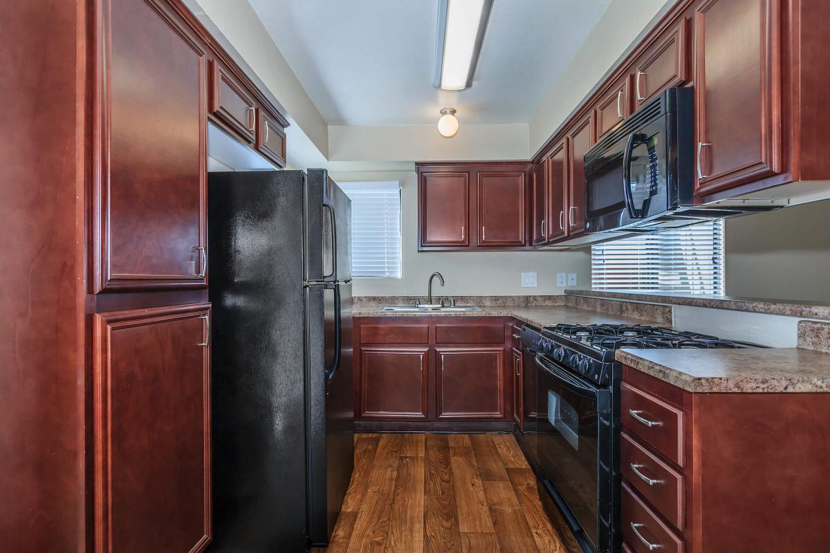 a large kitchen with stainless steel appliances and wooden cabinets