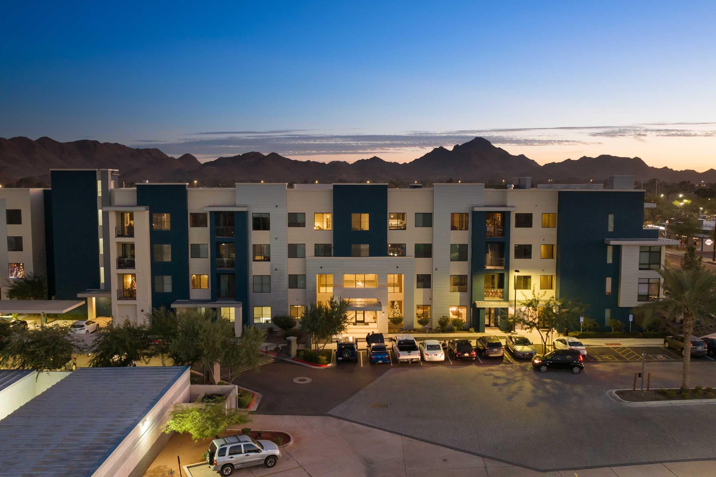  Modern apartment building at dusk, showcasing a mix of blue and light-colored exterior walls.