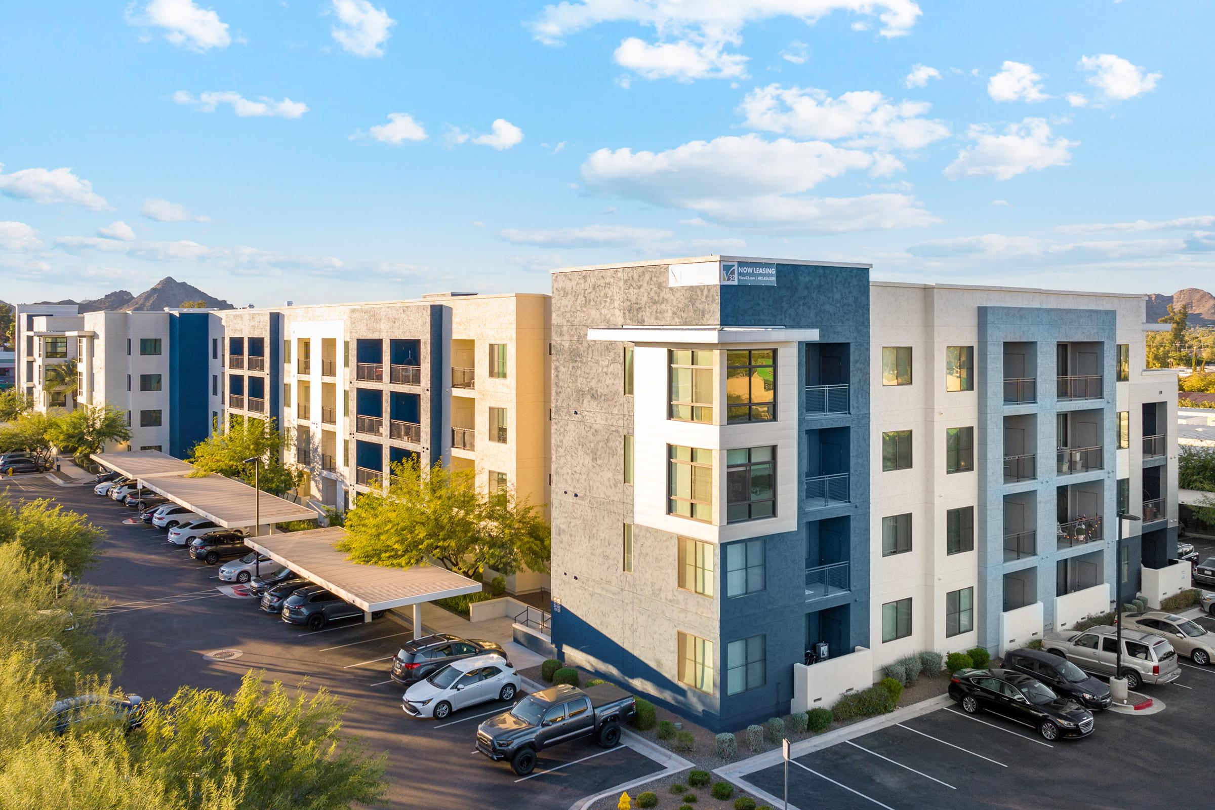  Modern apartment building with a mix of light and dark exterior colors, featuring multiple floors and balconies.