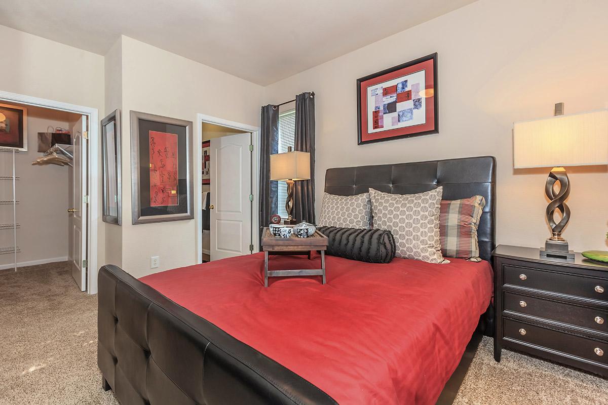 a bedroom with a large red chair in a room
