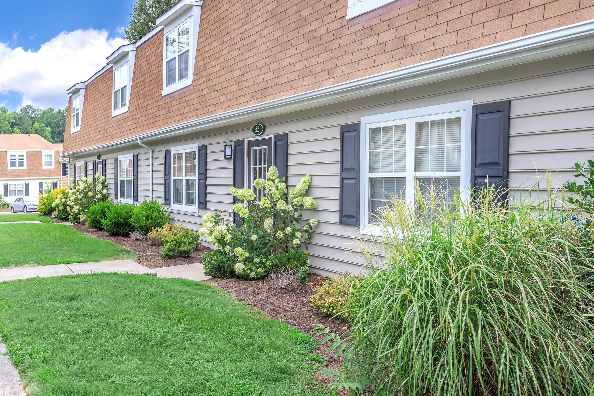 a large brick building with grass in front of a house