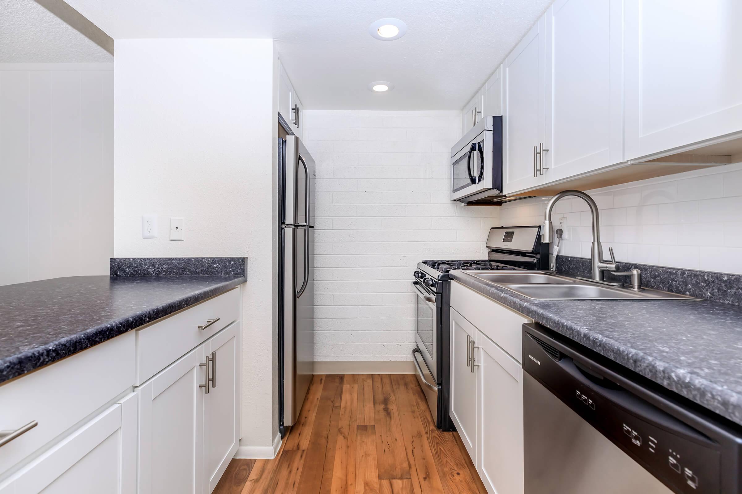 a modern kitchen with stainless steel appliances and wooden cabinets