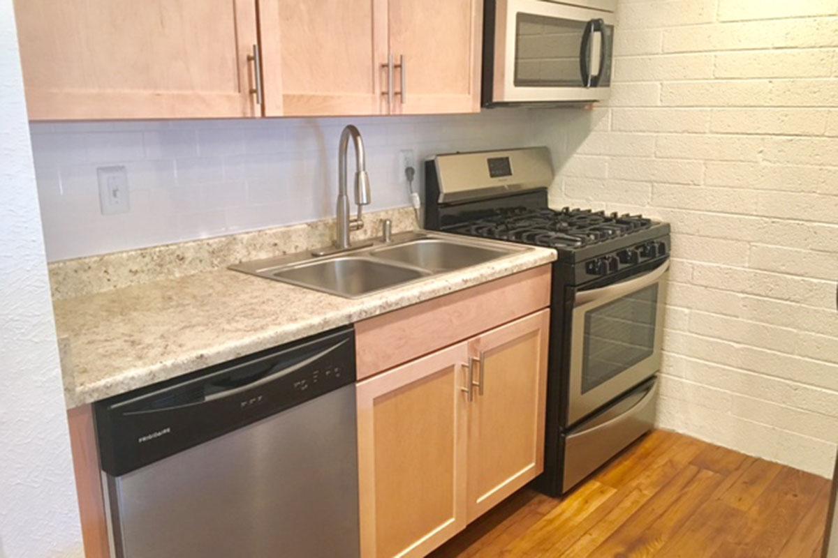 a kitchen with wooden cabinets and a black stove top oven