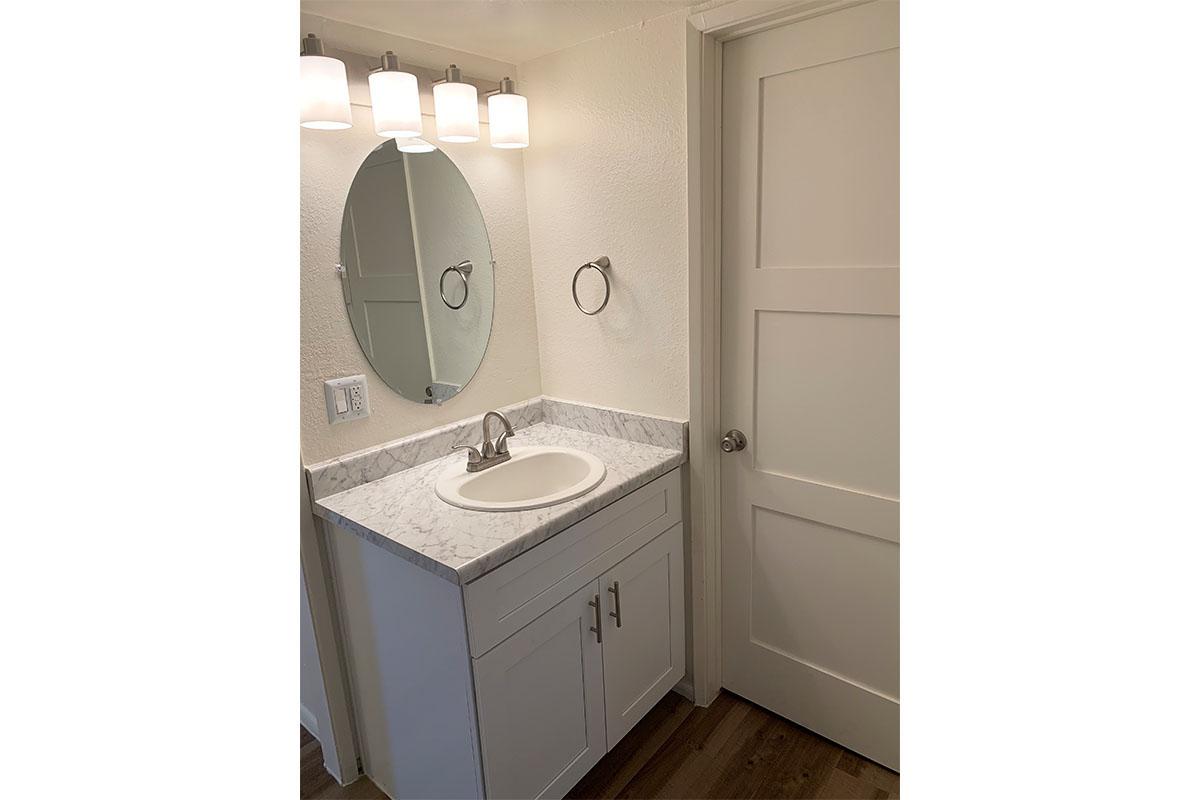 a white sink sitting under a mirror