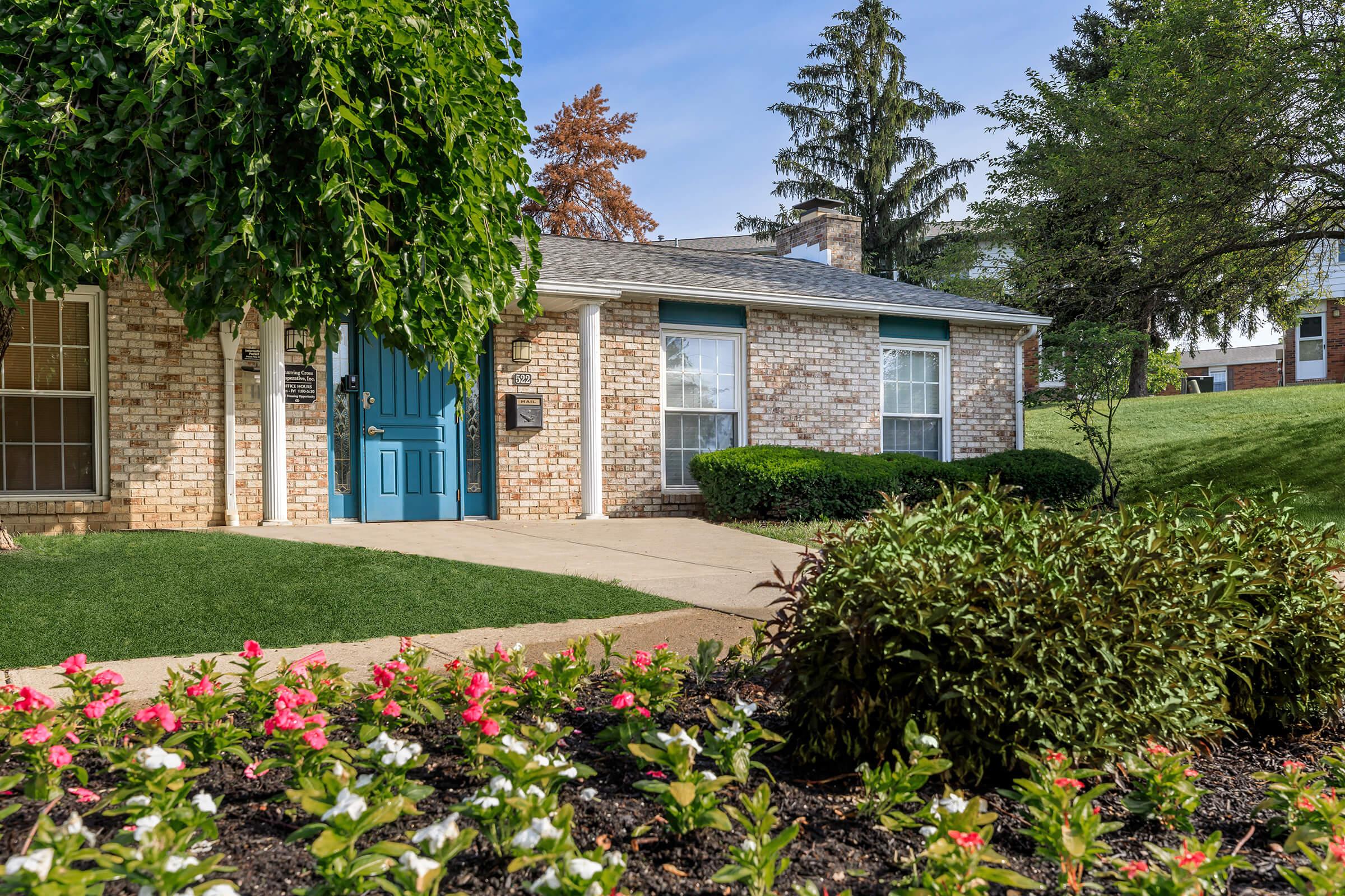 a close up of a flower garden in front of a house