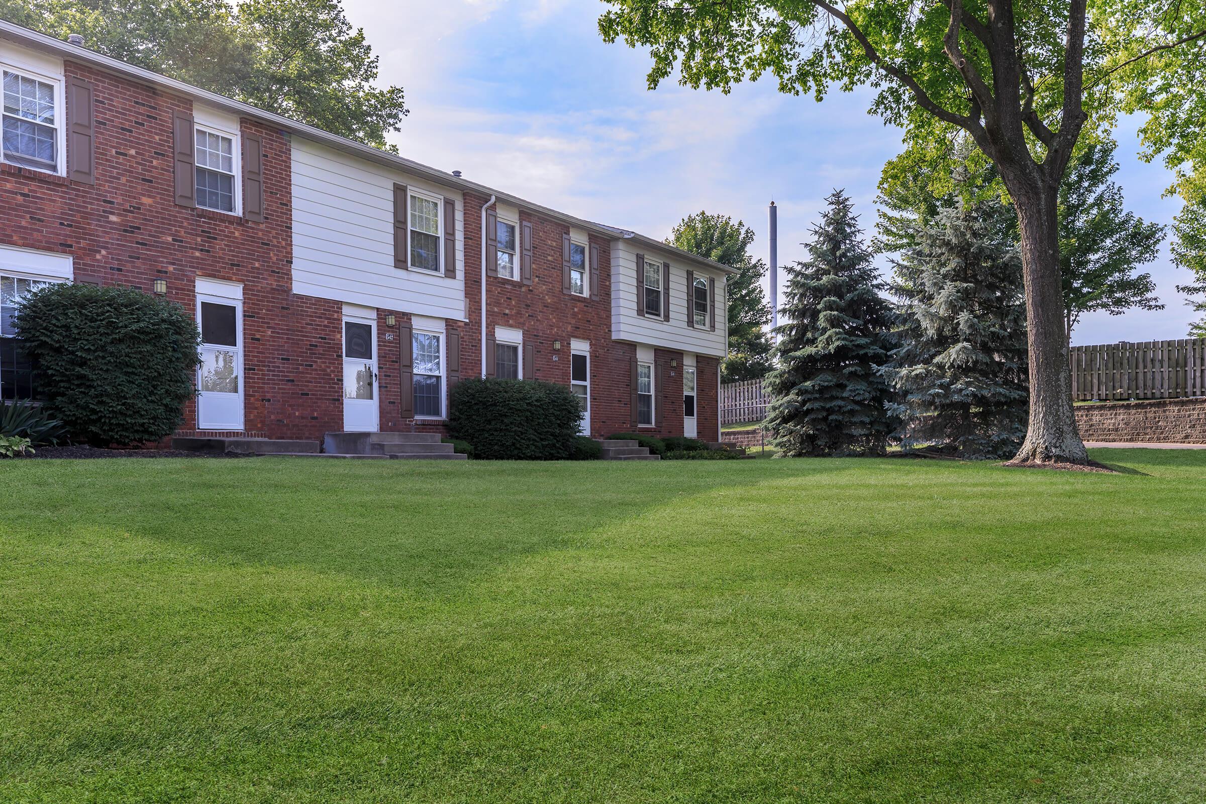 a large lawn in front of a brick building