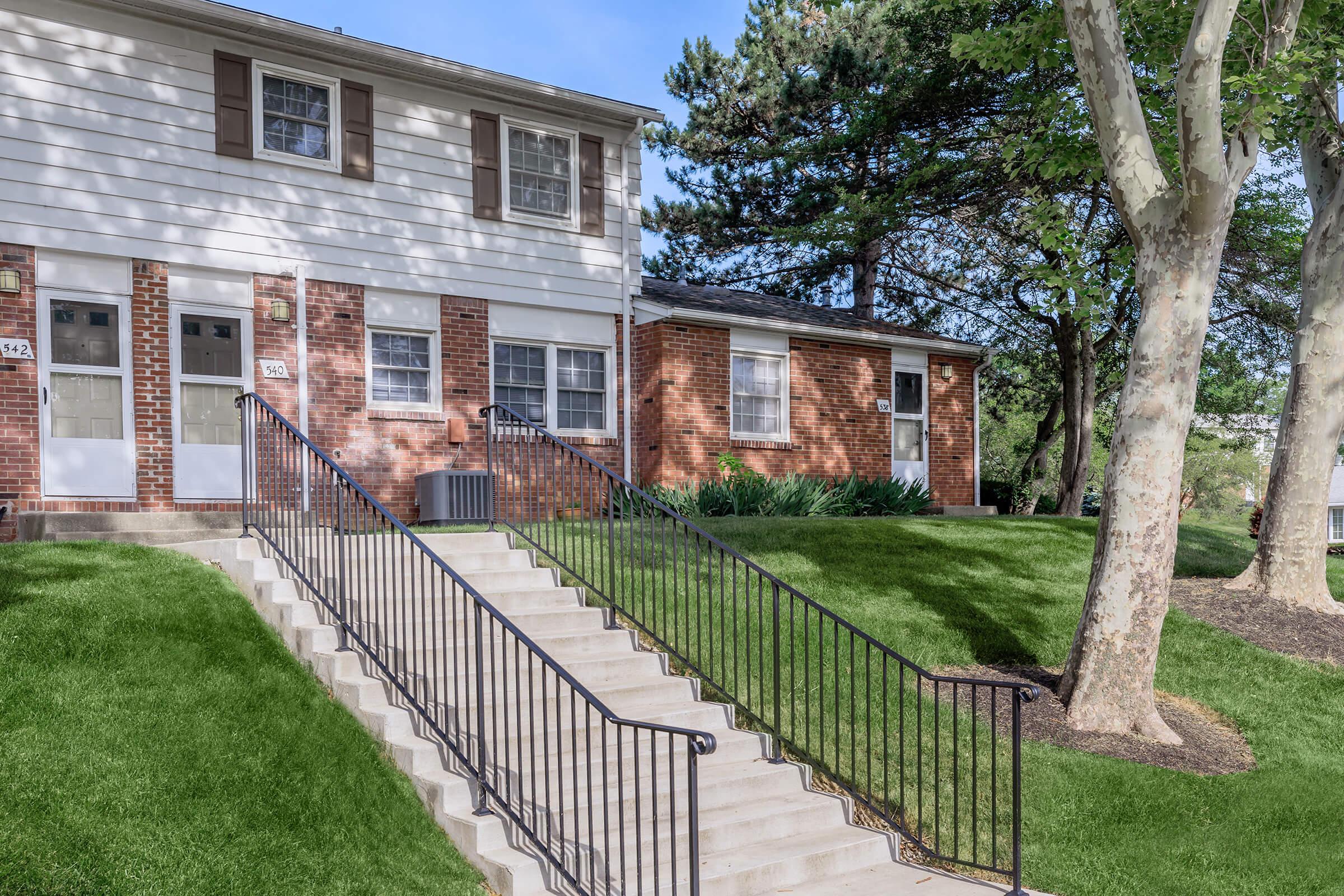 a house with a fence in front of a brick building