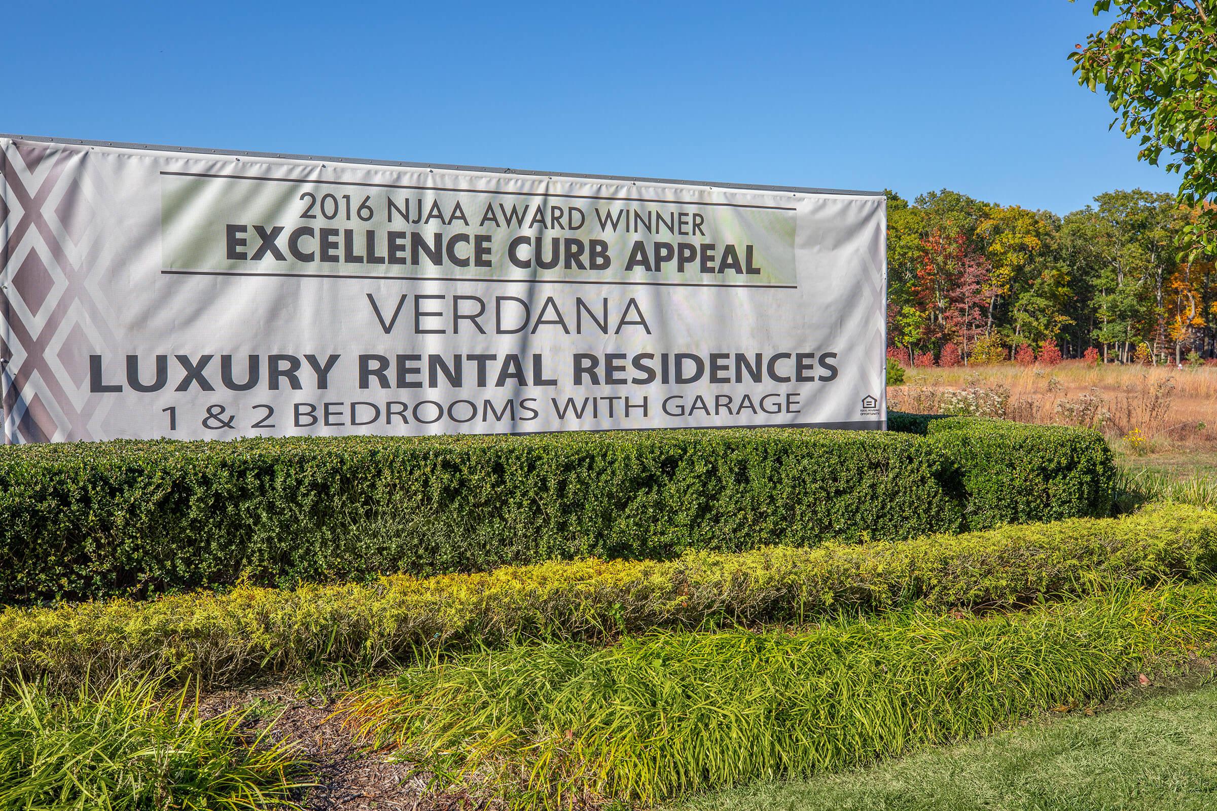 a sign in front of a green field