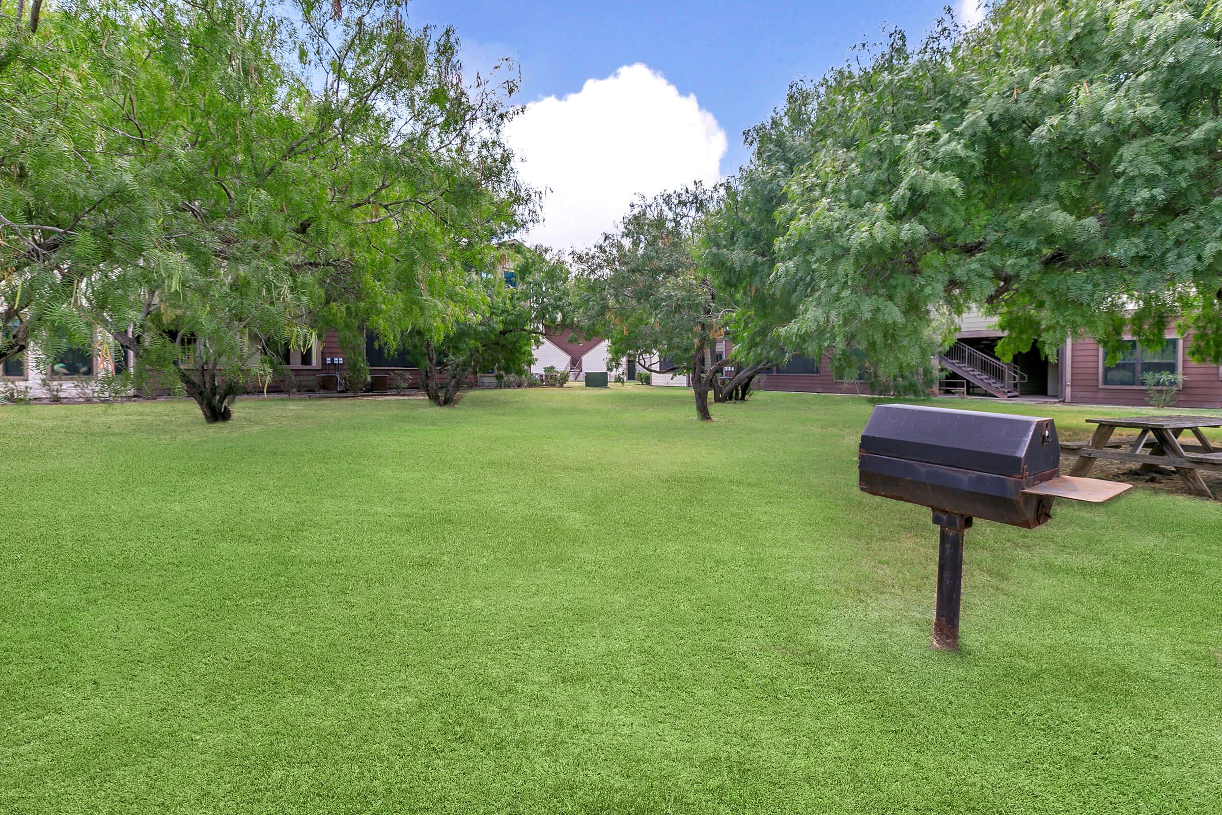 a group of lawn chairs sitting on top of a grass covered field