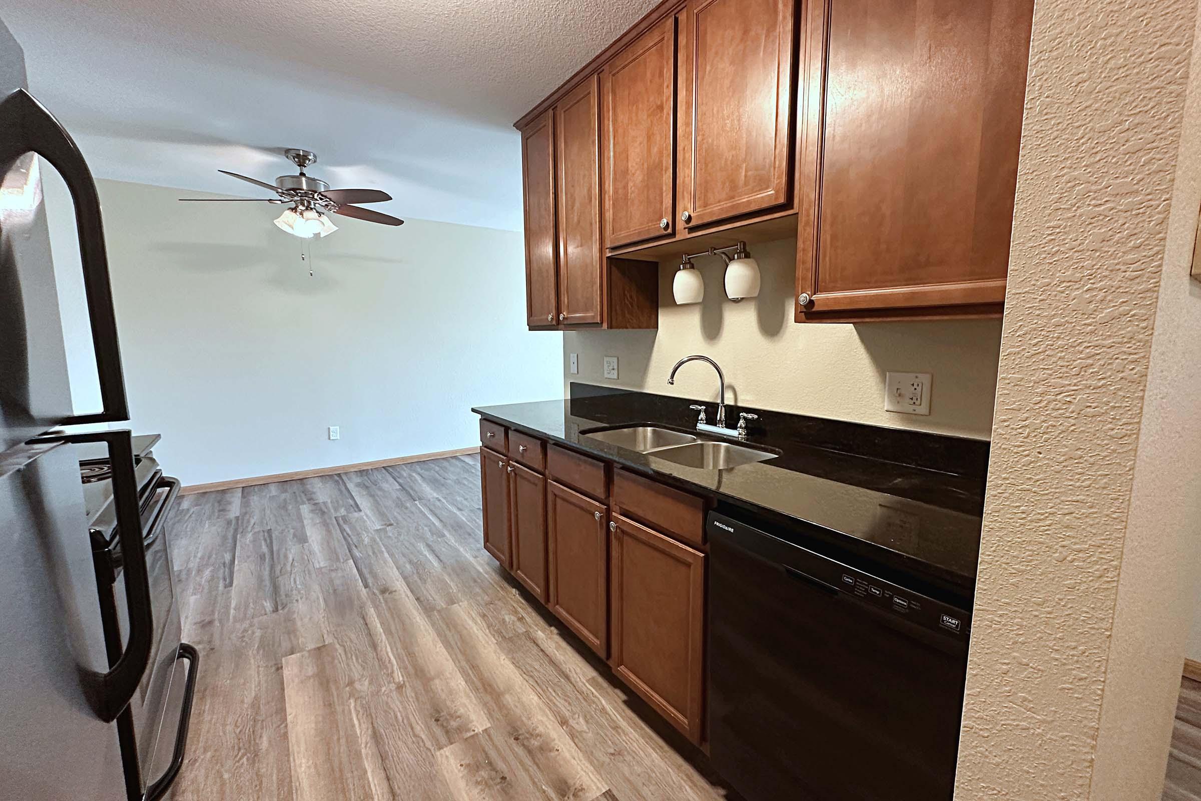 a large kitchen with stainless steel appliances and wooden cabinets