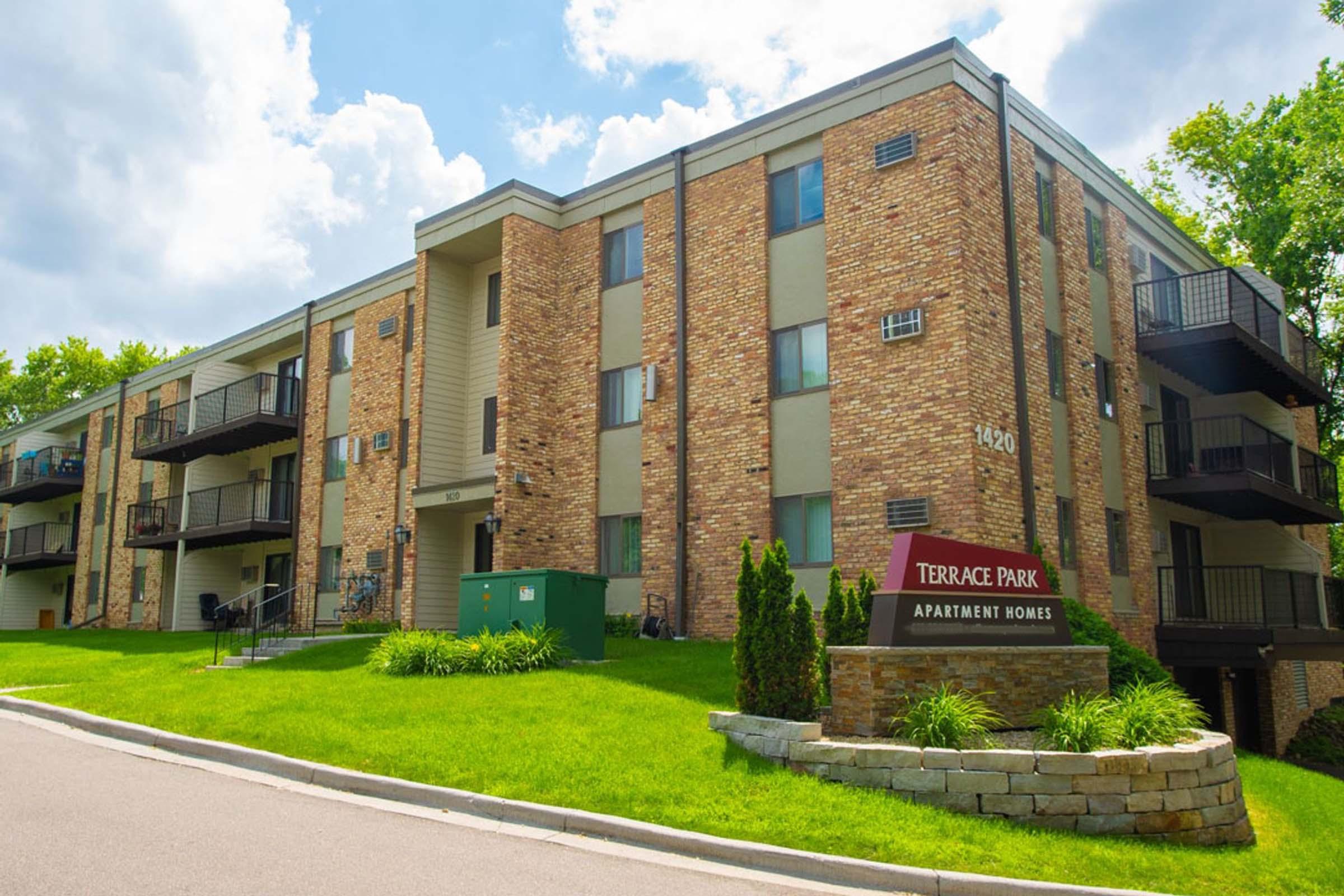 a large brick building with a sign on the side of a road