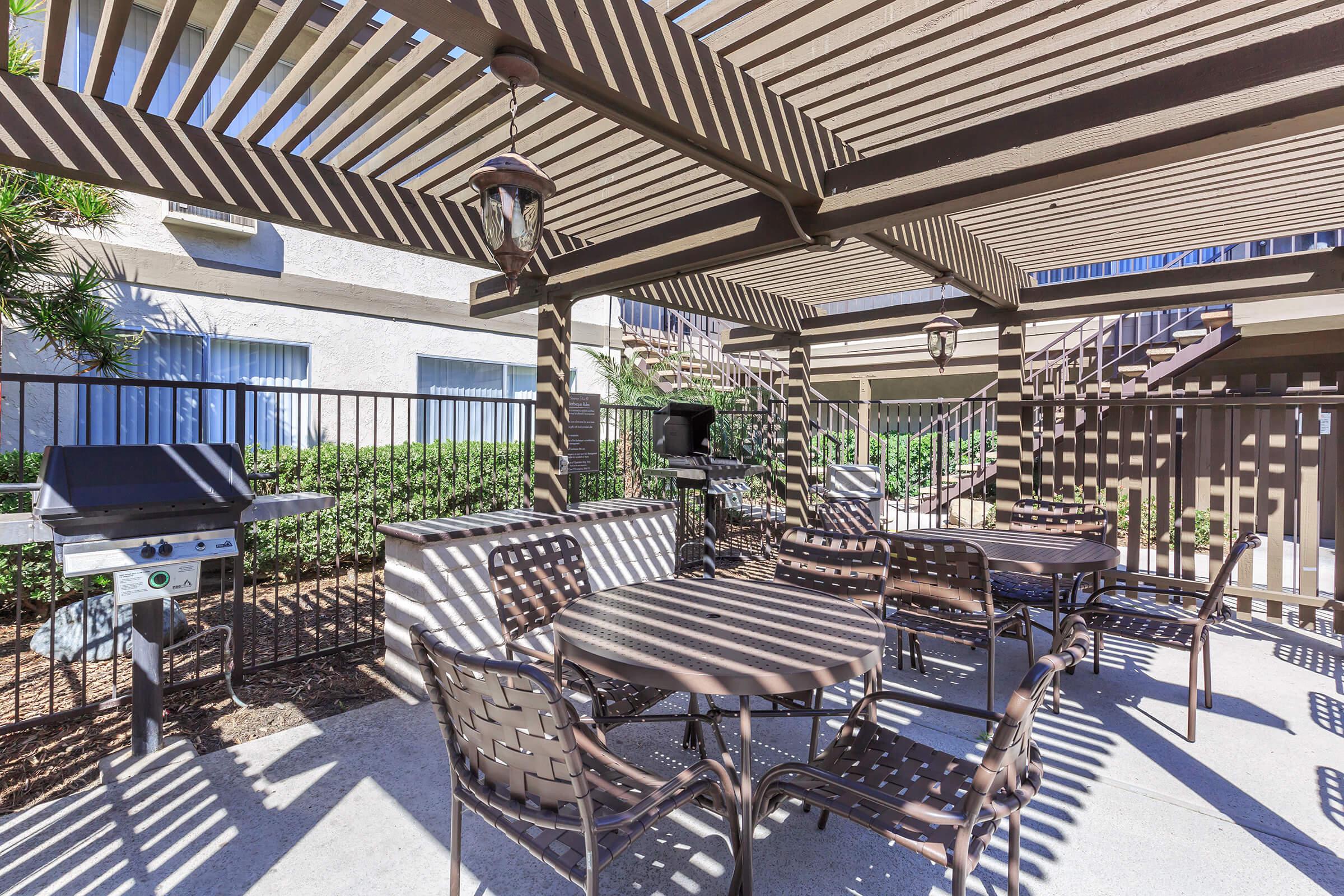 Barbecues with tables and chairs under a pergola